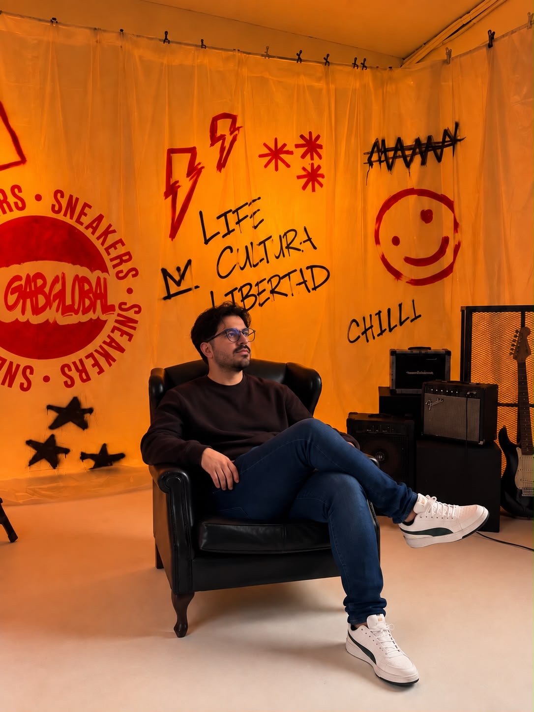 Alcides Gabriel sentado numa poltrona no estúdio da Gab Global, com grafites da marca ao fundo